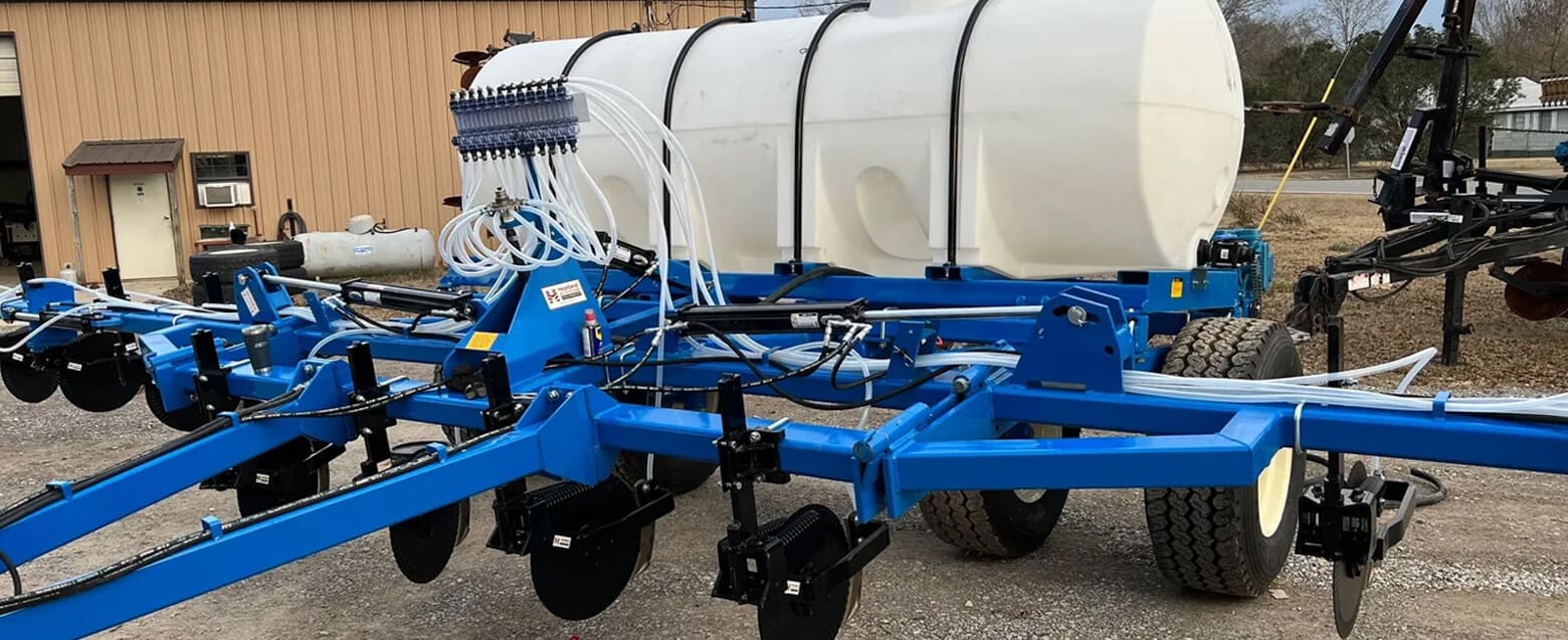 A blue and white trailer with two rows of barrels.