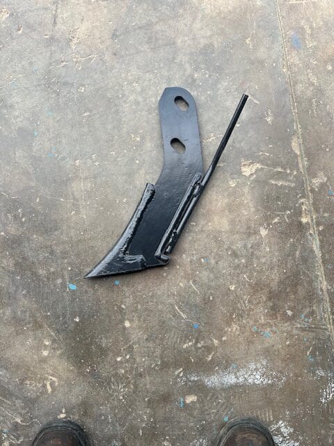 A black knife laying on the ground