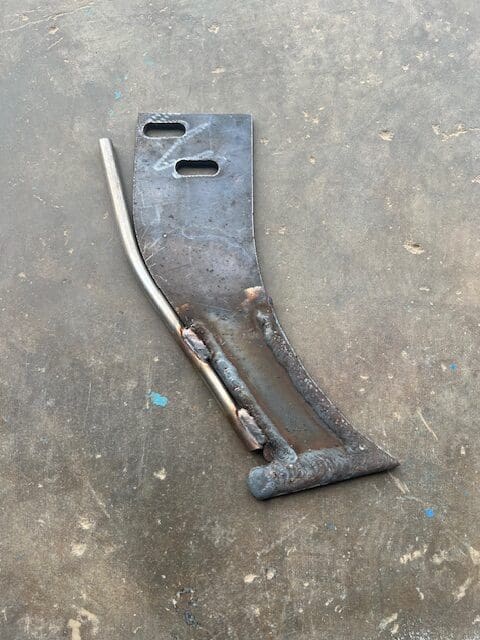 A rusty metal object with an iron handle.